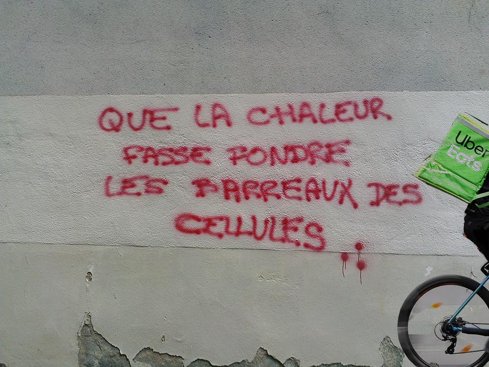 un uber à vélo devant un mur avec un graff