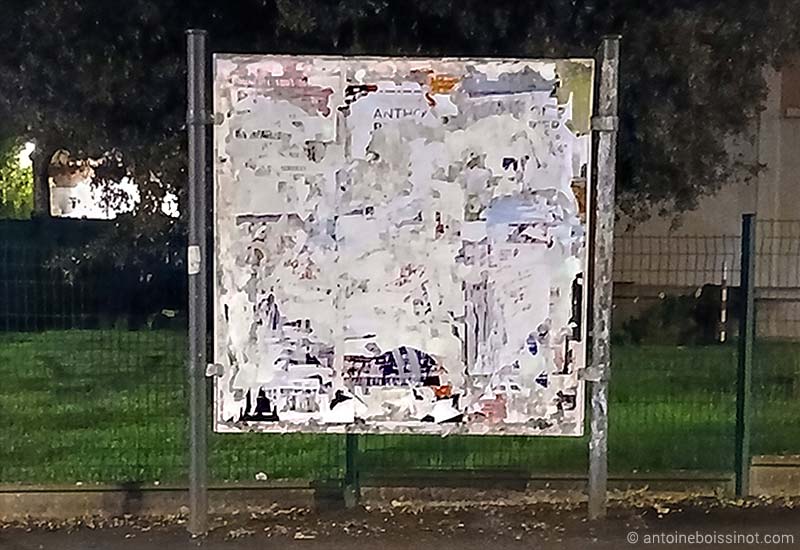 œuvre artistique fait de papiers déchirés sur panneau d'affichage publique à Bellejouanne